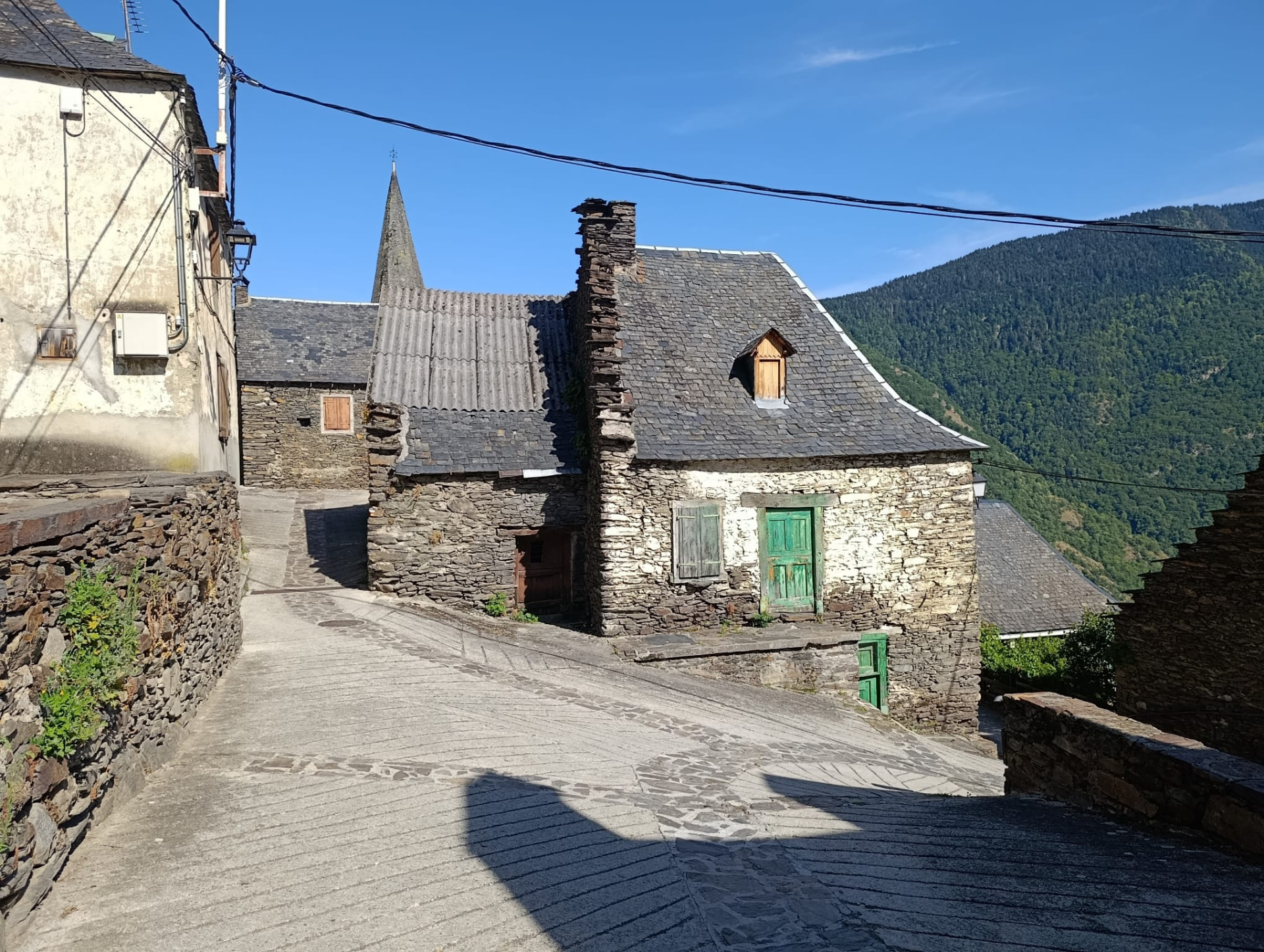 Carrer empedrat amb cases de pissarra en un poble del Pirineu